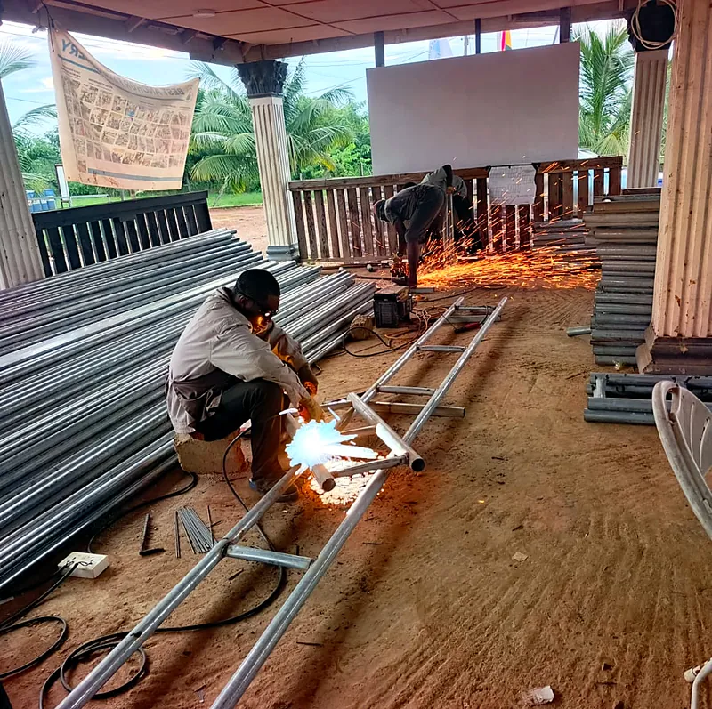 A welder building cage frames at the farm workshop